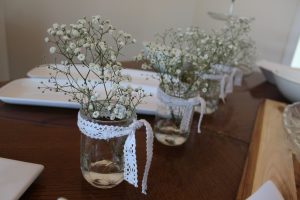 Inexpensive baby's breath in mason jars with a little bit of lace is the perfect {inexpensive} compliment to a rustic shower
