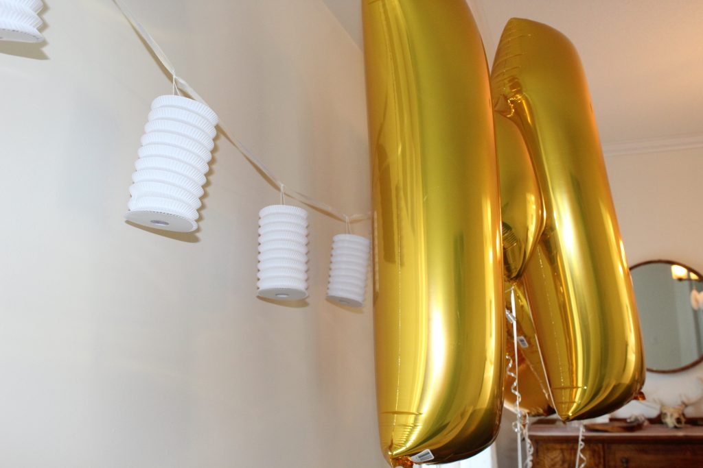 Create a fun selfie wall for guests with foil balloons, hanging paper lanterns, and a little bit of fun for everyone!